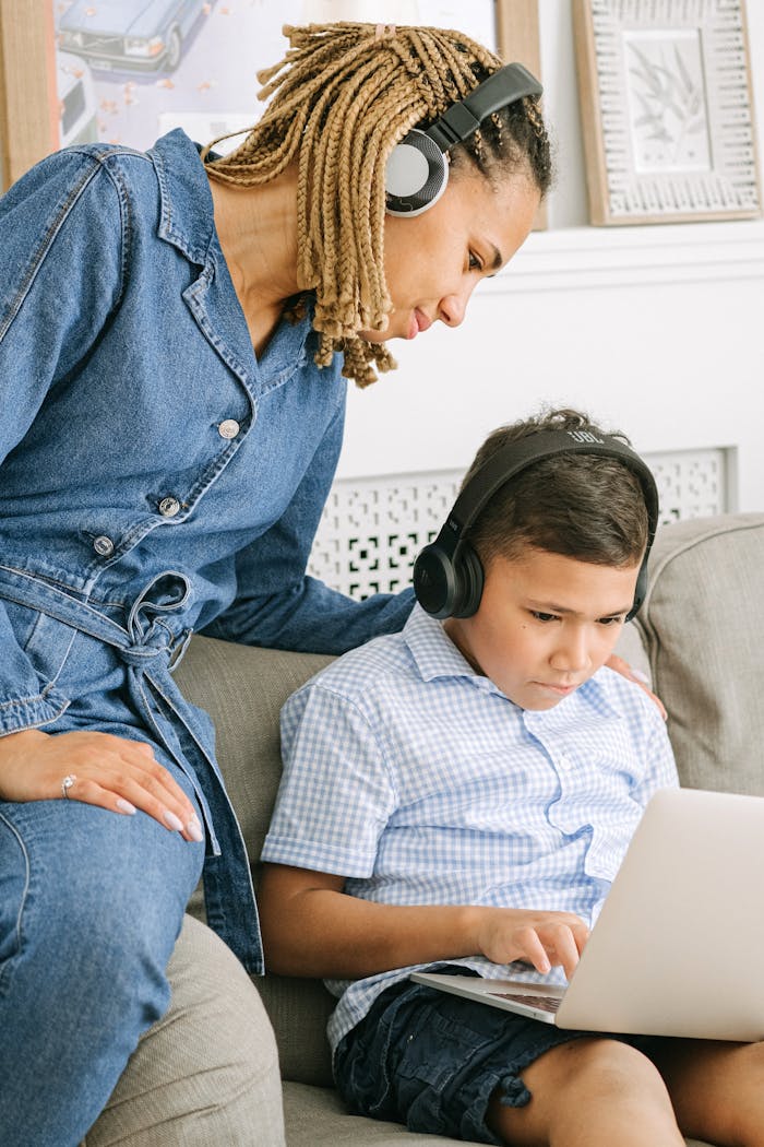 Services A mother supports her son during an online learning session at home.